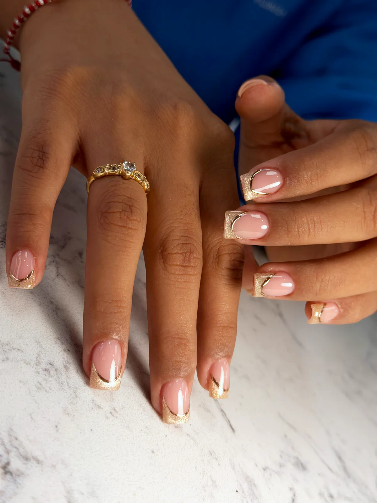 Short square nude nails with a gold-glitter V French tip and a fine gold line, by BeautyFusionClau in Sarasota, Florida