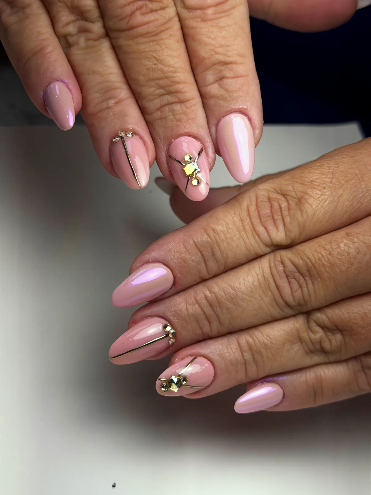 Long dusty-pink almond nails with lilac chrome, gold lines and rhinestones, by BeautyFusionClau in Sarasota, Florida